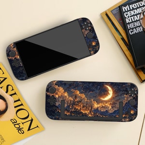 Op de afbeelding: Twee zwarte handheld gameconsoles met decoratieve skins. Eén skin heeft een nachthemelscène met een halve maan en een kasteelsilhouet. De andere heeft een donker patroon met oranje en blauwe accenten. Tijdschriften staan op de achtergrond.