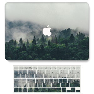 Pu&ograve; includere: Una skin per laptop con una scena di foresta nebbiosa. L'immagine presenta una foresta fitta con alberi alti e uno strato di nebbia che ricopre il paesaggio. La skin &egrave; progettata per adattarsi a un laptop e presenta una tavolozza di colori sottile e tenue.