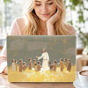 May include: A laptop skin featuring a digital illustration of a figure in a long robe standing in a field of yellow flowers, surrounded by a group of children. The background shows a muted green landscape with faint outlines of houses and trees.