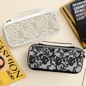 May include: Two rectangular carrying cases with top handles and zipper closures. One case features a white background with a beige floral lace pattern, while the other case features a black background with a white floral lace pattern.