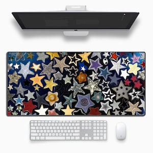 Op de afbeelding: Een kleurrijke muismat met een herhalend patroon van sterren in verschillende kleuren en ontwerpen op een donkerblauwe achtergrond.