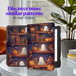 May include: A black e-reader with a Halloween-themed cover featuring a bookshelf with pumpkins, ghosts, and books. The cover has the text "Discover more similar patterns in our listing" in purple.