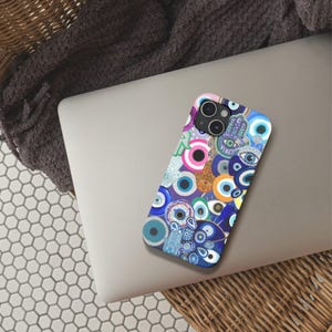 Könnte beinhalten: Eine farbenfrohe Handyhülle mit einem Muster aus blauen bösen Augen, Hamsa-Händen und den Worten "Only Good Vibes".