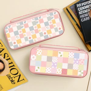 Pode incluir: Duas capas retangulares rosa com fecho de correr e pega. As capas apresentam um design de patchwork com quadrados pastel e padrões florais. Uma capa tem um padrão xadrez com flores, a outra um patchwork de vários padrões.