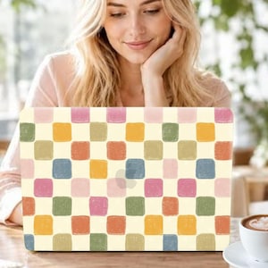 May include: A laptop skin featuring a repeating grid pattern of rounded squares in muted shades of pink, yellow, orange, green, and blue against a cream background. The design has a textured, hand-painted appearance with visible brush strokes.