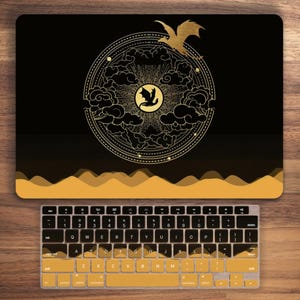 May include: Black laptop skin with a gold design of a dragon flying through clouds and a circle with a dragon inside. The design is on a black background with a gold border.