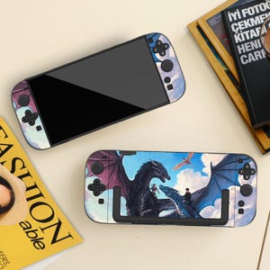 May include: Two Nintendo Switch consoles with custom skins. One console is displayed with a black screen and a sky-themed design on the controllers. The other console features a dragon graphic with a blue sky background.