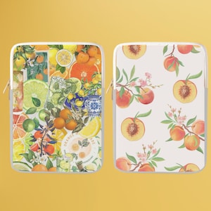 Puede incluir: Dos fundas para portátil con diferentes diseños de frutas. La primera funda presenta un collage colorido de limones, limas, naranjas y un vaso de limonada. La segunda funda presenta un fondo blanco con un patrón repetido de melocotones y flores de melocotón. Ambas fundas tienen una cremallera.