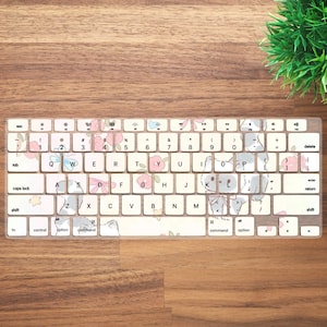 May include: A clear keyboard cover with a floral and animal print design. The cover features a variety of small animals, including cats, rabbits, and birds, as well as flowers in pink, blue, and yellow. The cover is designed to fit a standard US keyboard.