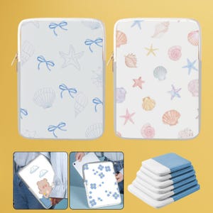 Op de afbeelding: Twee tablethoesjes met verschillende ontwerpen. Een hoesje heeft een blauw en wit schelp- en zeestermotief. Het andere hoesje heeft een roze en wit schelp- en zeestermotief. Beide hoesjes hebben een ritssluiting.