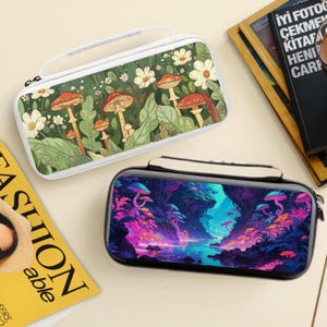 Könnte beinhalten: Zwei rechteckige Etuis mit Griffen. Ein Etui hat einen weißen Hintergrund mit einem Pilz- und Blumendesign. Das andere Etui hat einen schwarzen Hintergrund mit einem farbenfrohen Landschaftsdesign. Beide Etuis haben einen weißen Griff und Reißverschluss.