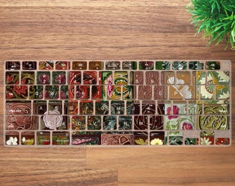 May include: A decorative keyboard skin featuring a floral and botanical design. The keys are adorned with various patterns and colors, including red, pink, green, and brown. The keyboard skin is placed on a wooden surface.
