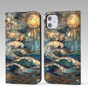 以下が含まれることがあります： 青、金、白の色合いで太陽、雲、海の波を描いたステンドグラスのデザインの携帯電話ケース。ケースはフォリオスタイルで、画面を覆うカバーが付いています。デザインは質感のある外観をしています。