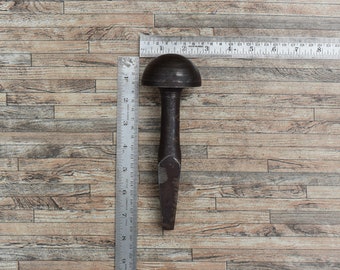 Peut inclure: Un outil en métal vintage avec une tête arrondie et un long manche pointu. L'outil mesure environ 15 cm de long et repose sur une surface en bois.