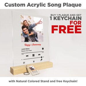 Könnte beinhalten: Individuelle Acrylsong-Plakette mit einem Foto eines Paares, einem Musikplayer-Design und dem Text "Happy 1 Anniversary". Die Plakette steht auf einem Holzständer und beinhaltet einen kostenlosen Schlüsselanhänger.