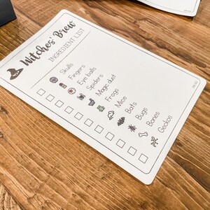 May include: A white checklist with the title "Witches' Brew" and a list of ingredients for a witch's brew, including skulls, fingers, eye balls, spiders, magic dust, frogs, mice, bats, bugs, bones, and geckos. Each ingredient is accompanied by a small icon.