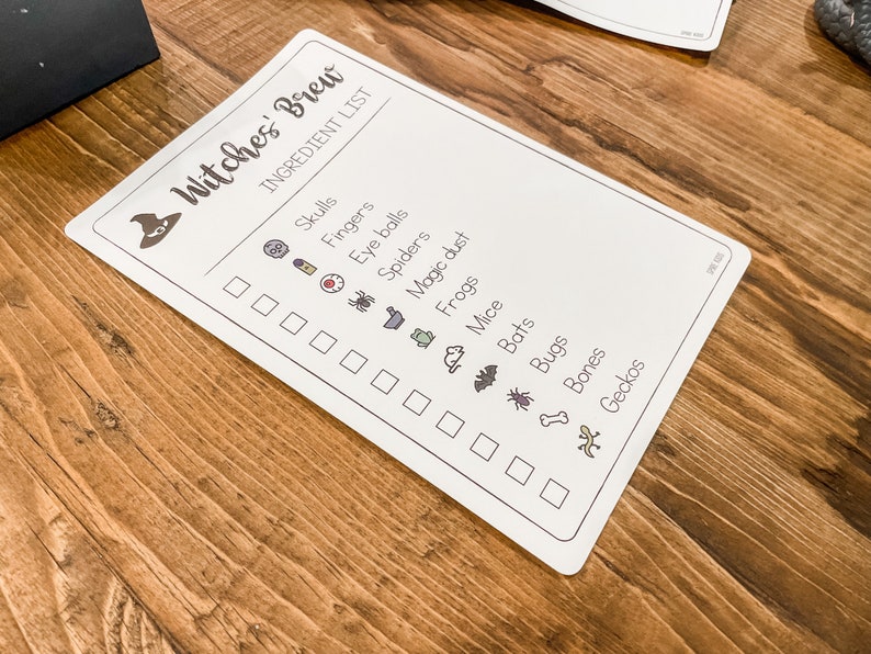 May include: A white checklist with the title "Witches' Brew" and a list of ingredients for a witch's brew, including skulls, fingers, eye balls, spiders, magic dust, frogs, mice, bats, bugs, bones, and geckos. Each ingredient is accompanied by a small icon.