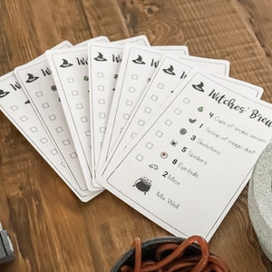 May include: A set of printable Halloween witch's brew recipe cards with a checklist of ingredients and a cauldron illustration. The ingredients include cups of snake venom, a scoop of magic dust, skeletons, spiders, eye balls, and mice.