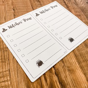 May include: A white checklist with the text "Witches' Brew" at the top. The checklist has a witch's hat and cauldron graphic. There are blank lines with checkboxes next to each line.