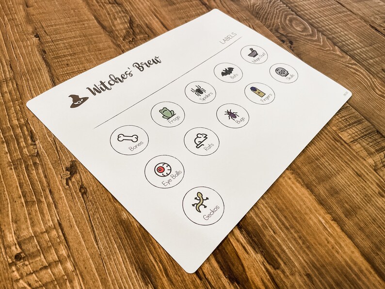 May include: A white game board with the title "Witches' Brew" and a witch's hat icon. The board has circles with various Halloween-themed images and labels, such as "Bones", "Eye Balls", "Frogs", "Rats", "Spiders", "Bugs", "Toads", "Fingers", "Bats", and "Geckos".