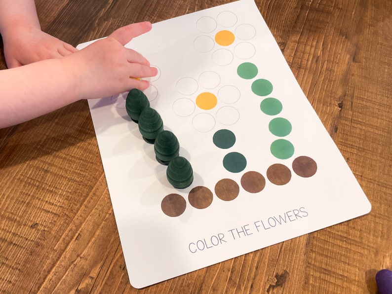 K&ouml;nnte beinhalten: Eine wei&szlig;e Karte mit dem Text "Color the Flowers" und zwei Blumenumrissen. Die Blumen bestehen aus wei&szlig;en Kreisen mit gelben Zentren. Die Karte ist von gr&uuml;nen und braunen Kreisen umgeben.