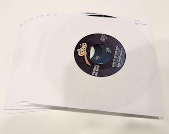 May include: A stack of white paper record sleeves with a 45 RPM vinyl record visible. The record label is black with the text "Take It On The Run" by REO Speedwagon. The Epic Records logo is also visible.