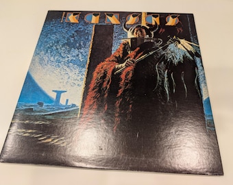 May include: Album cover featuring the word "KING" in a stylized font. The artwork depicts a figure in a red cloak with horns, holding a staff, set against a blue and black background with a moon and a tower.