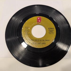May include: A black vinyl record with a yellow and gold label. The label reads "I'D REALLY LOVE TO SEE YOU TONIGHT" by Dee Dee Sharp Gamble. The record is a stereo recording, ZS8 3636.