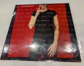 May include: A black and red record with the text "LOVERBOY" and lyrics printed on the cover. The record features a woman wearing a black shirt and red pants.