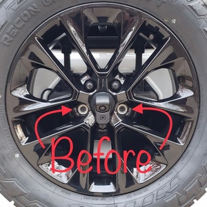 May include: Black alloy wheel with a tire labeled "RECON GRAPPLER A/T". The wheel has a glossy finish and a central hub with lug nuts. The word "Before" is written in red across the image.