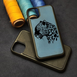May include: A blue phone case with a black jaguar design. The case is made of leather and has a black border.