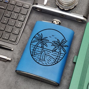 Pode incluir: Uma garrafa de metal azul com uma ilustração em preto e branco de palmeiras e uma prancha de surf numa praia. A garrafa tem uma tampa prateada.