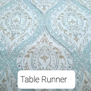 May include: A blue and gold table runner with a damask pattern. The text "Table Runner" is printed on a white label.