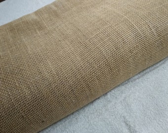 May include: A roll of natural brown burlap fabric with a woven texture.