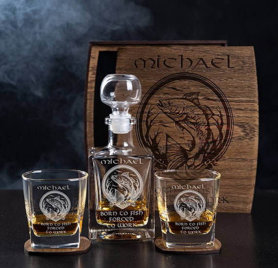 Fishing-themed engraved whiskey set in a wood box — hyper-specific niche theming elevates it from 'generic decanter' to 'perfect gift for that one guy'.