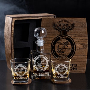 Peut inclure: Une boîte en bois contenant une carafe en verre et deux verres. La boîte est gravée des mots "United States Armed Forces Veteran" et "Any Logo, Pattern or Symbol".