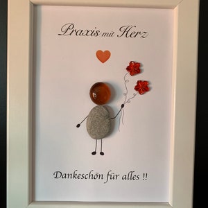 Könnte beinhalten: Ein gerahmtes Kunstwerk mit weißem Hintergrund und einer handgezeichneten Figur, die eine Blume hält. Der Text "Praxis mit Herz" und "Dankeschön für alles!!" ist auf dem Kunstwerk geschrieben.