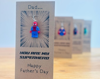 May include: A brown card with the text "Dad... You are my superhero Happy Father's Day" and a small red and blue Spiderman Lego figure hanging from it.