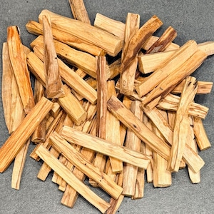 Puede incluir: Un montón de palitos de Palo Santo marrones y beige, un tipo de madera aromática utilizada para la limpieza espiritual y el smudging.