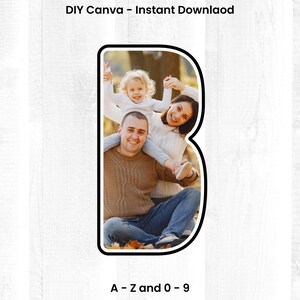May include: A family of three poses for a photo in a letter B shape. The family is sitting on the ground with leaves around them. The father is wearing a brown sweater and blue jeans. The mother is wearing a white sweater and blue jeans. The daughter is wearing a pink shirt and white pants. The letter B is black and white.