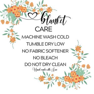 K&ouml;nnte beinhalten: Wei&szlig;er Hintergrund mit dem Text "Blanket Care" und Pflegehinweisen. Der Text ist von floralen Arrangements in Orange, Gelb und Gr&uuml;n umgeben. Die Worte "Hand made with love" sind ebenfalls enthalten.