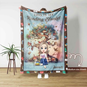 Może przedstawiać: Średniej wielkości (127x152 cm) koc do czytania o fantazyjnym wzorze. Koc przedstawia kreskówkową ilustrację dziewczyny czytającej pod drzewem pełnym książek. Tekst "THIS IS MY Reading Blanket" jest wyświetlany u góry.