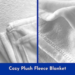 Op de afbeelding: Close-up van een wit, pluche fleece deken. Het deken is gevouwen en laat de zachte textuur van de stof zien. Het deken wordt beschreven als "Gezellig Pluche Fleece Deken".