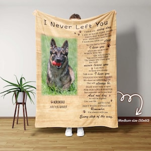 Puede incluir: Una manta beige de tamaño mediano (127x152 cm) con un perro pastor alemán sosteniendo una pelota roja. La manta tiene el texto "I Never Left You" y un poema. El nombre y la fecha del perro también están impresos en la manta.