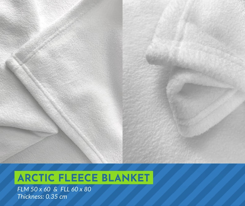 May include: Close-up of a white fleece blanket with a soft, fuzzy texture. The blanket is folded over, showing the stitching along the edge. The text "ARCTIC FLEECE BLANKET" is printed in green letters on a blue and white striped background. The text "FLM 50 x 60 & FLL 60 x 80" and "Thickness: 0.35 cm" is also printed below the blanket.