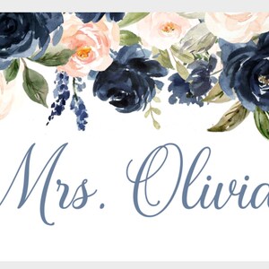 May include: A white background with a floral design in shades of blue and pink. The text "Mrs. Olivia" is written in blue script.