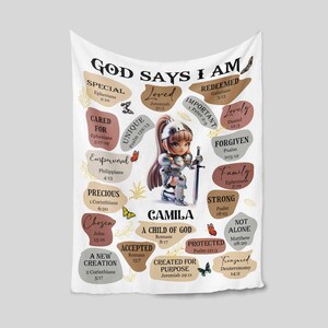 May include: A white blanket with a colorful design featuring a girl in armor and the words "God Says I Am" with bible verses. The girl is kneeling and holding a sword. The blanket is decorated with butterflies and flowers.