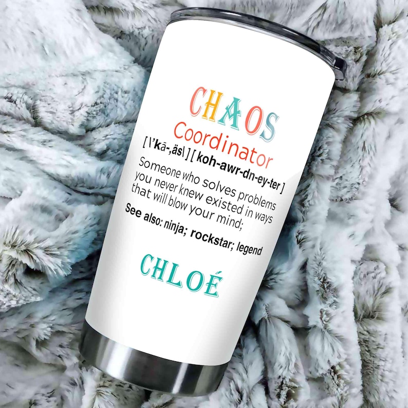 May include: A white stainless steel tumbler with the words "CHAOS Coordinator" in colorful text. The tumbler also includes a definition and the name "CHLO&Eacute;". The tumbler is on a soft, textured surface.