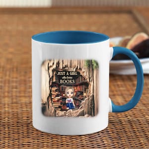 Op de afbeelding: Witte keramische mok met een blauwe binnenkant en handvat. De mok heeft een afbeelding van een meisje omringd door boeken, met de tekst "JUST A GIRL who loves BOOKS". De mok staat op een geweven oppervlak.