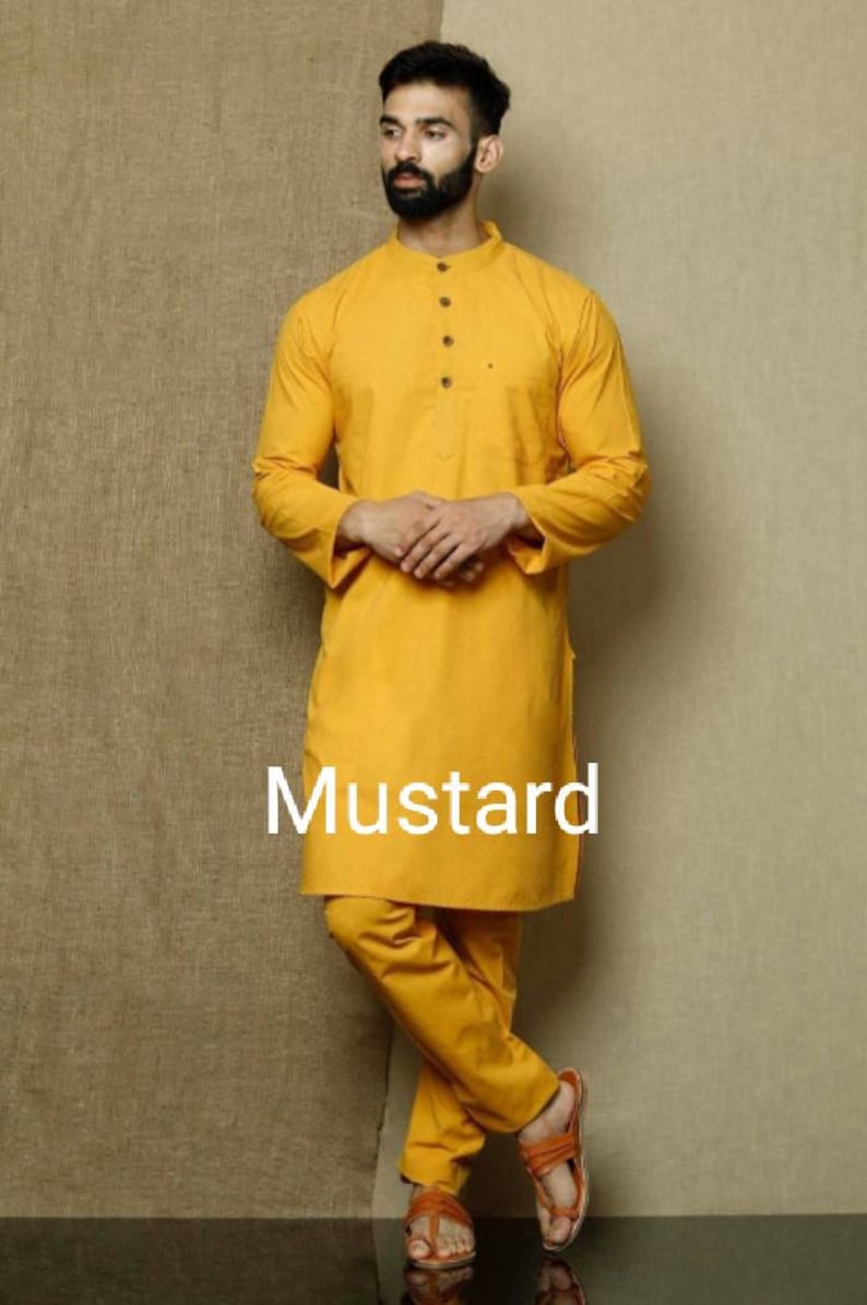 May include: A mustard yellow kurta and pajama set. The kurta has a mandarin collar and a button closure. The pajama pants are loose fitting.